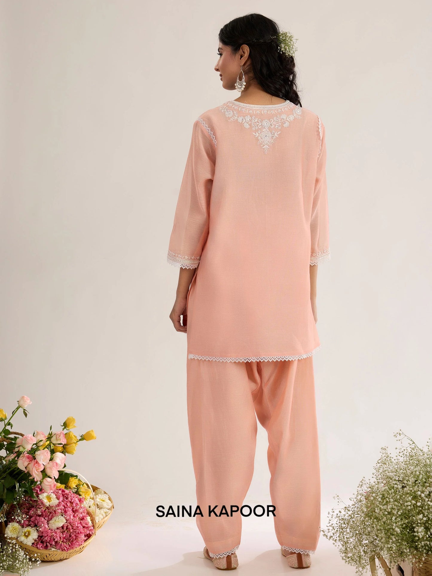 Peach pink Chanderi kurta back view with embroidered floral motif bordered in lace, three-quarter sleeves with lace-trimmed cuffs, and matching salwar - Saina Kapoor