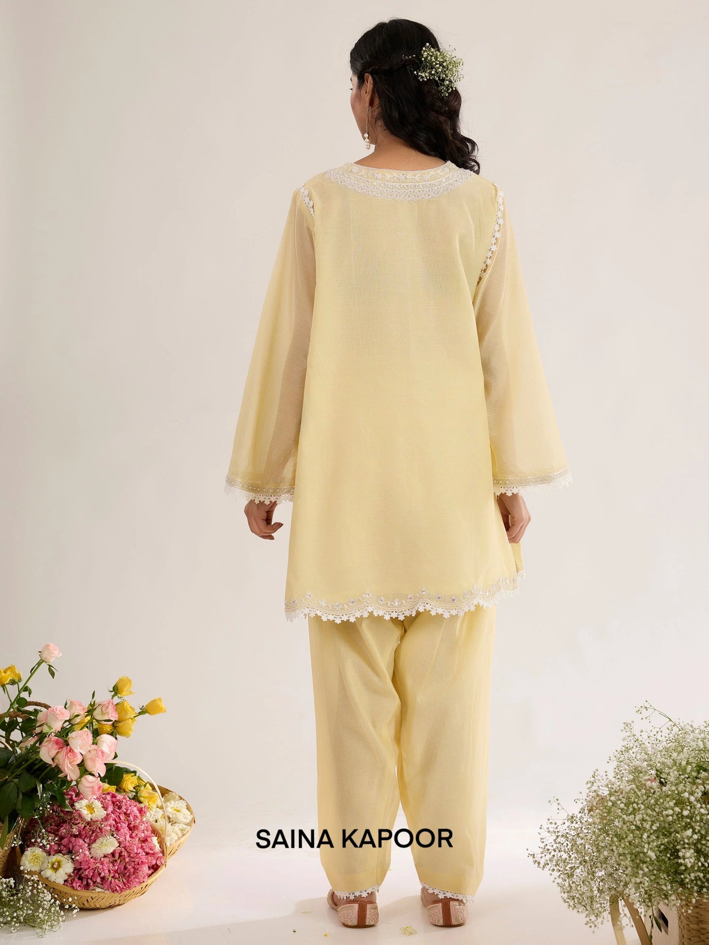 Pale yellow Chanderi kurta back view with round neckline bordered in lace, long sleeves with lace-trimmed cuffs, and matching salwar - Saina Kapoor