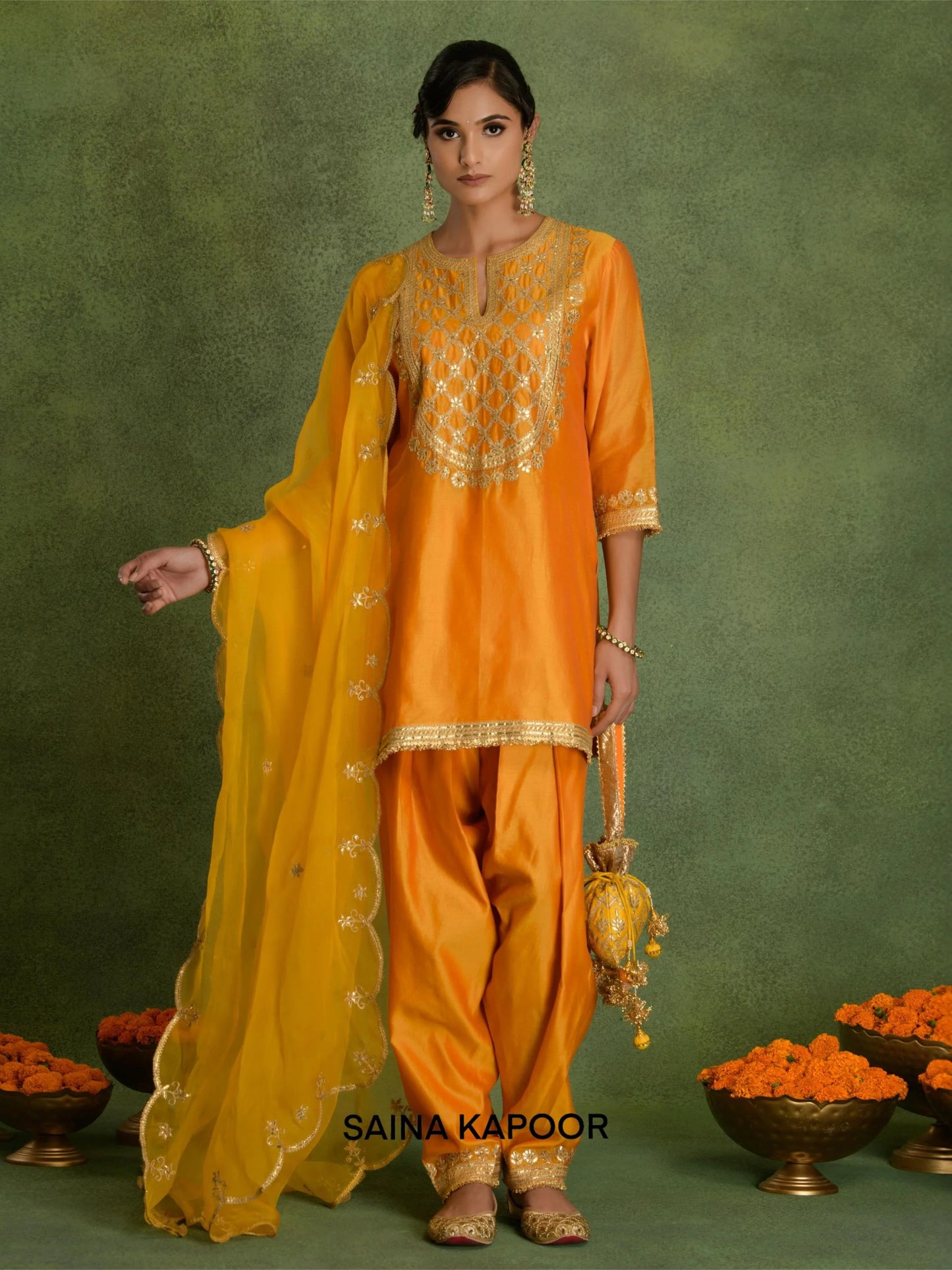 Orange marigold Chanderi short A-line kurta DWIJA with gold gota patti geometric trellis embroidered keyhole yoke, matching dhoti salwar with embroidered ankle cuffs, contrasting mustard dupatta & potli bag — Saina Kapoor
