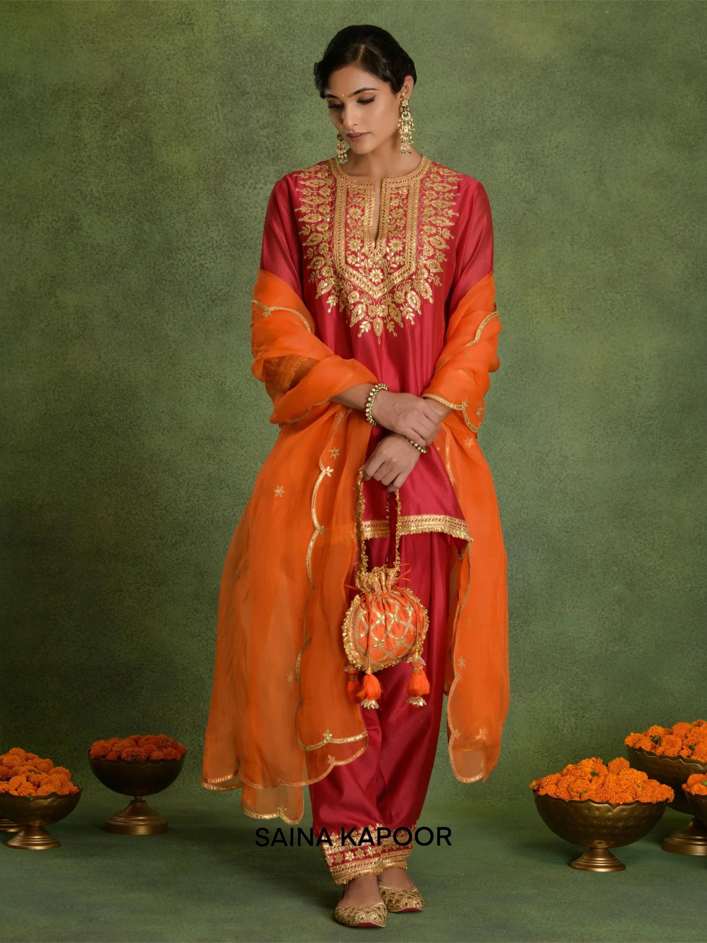 Fuchsia Chanderi short A-line kurta DHANI with gold gota patti embroidered keyhole yoke, matching dhoti salwar with embroidered ankle cuffs, contrasting orange dupatta & potli bag — Saina Kapoor