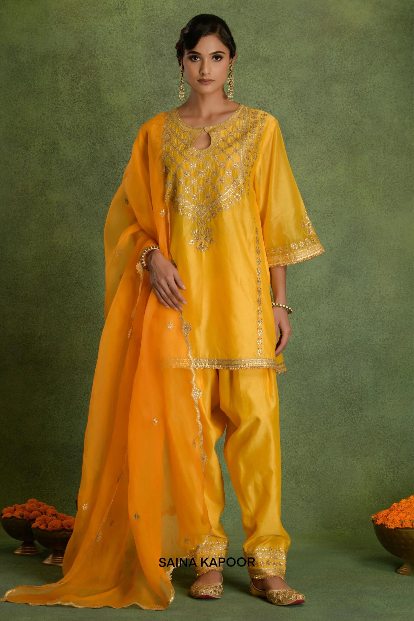 Yellow Chanderi short kurta salwar set with organza dupatta and potli by Saina Kapoor front view