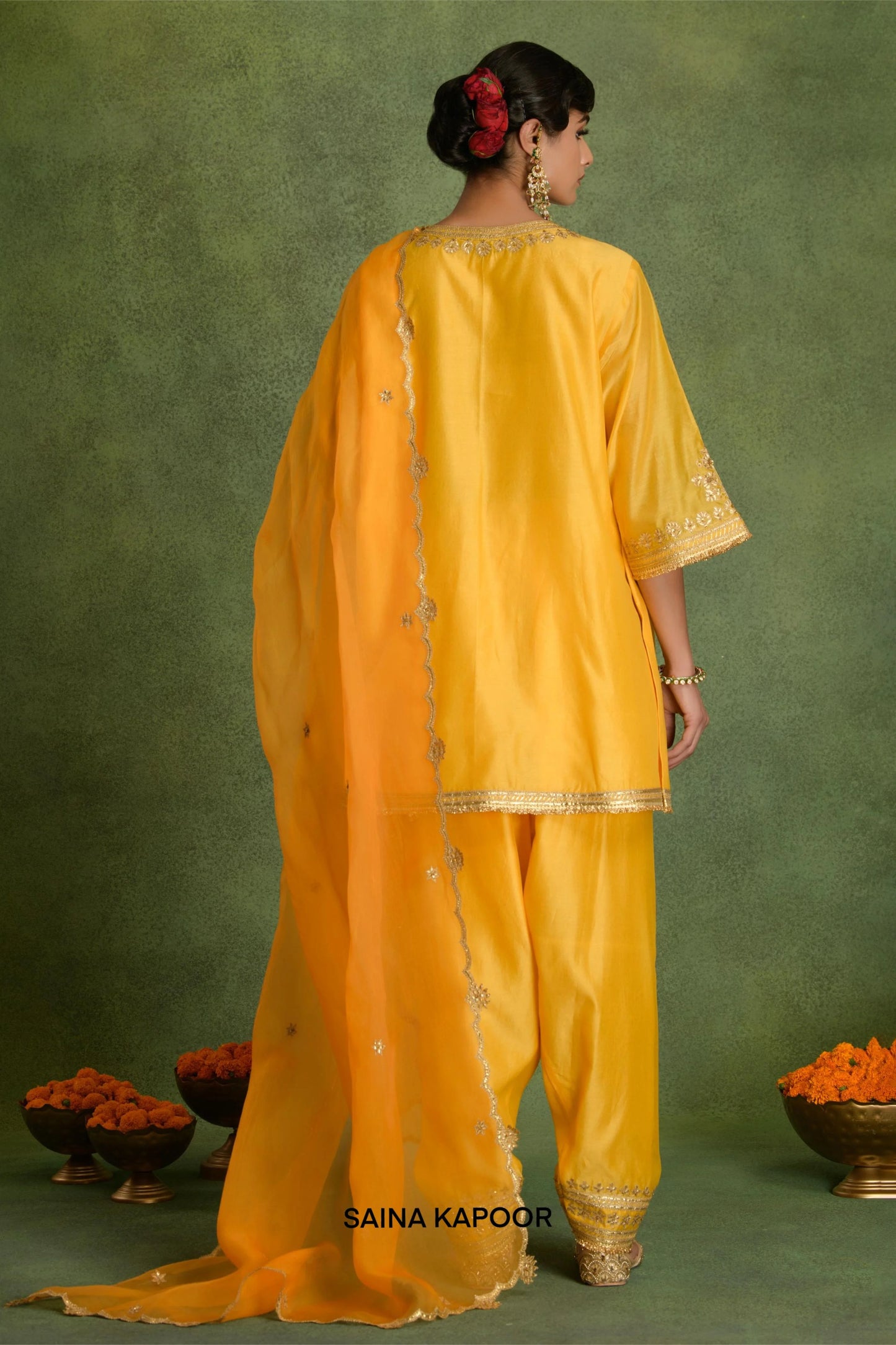 Back view of yellow Chanderi short kurta with salwar and organza dupatta by Saina Kapoor