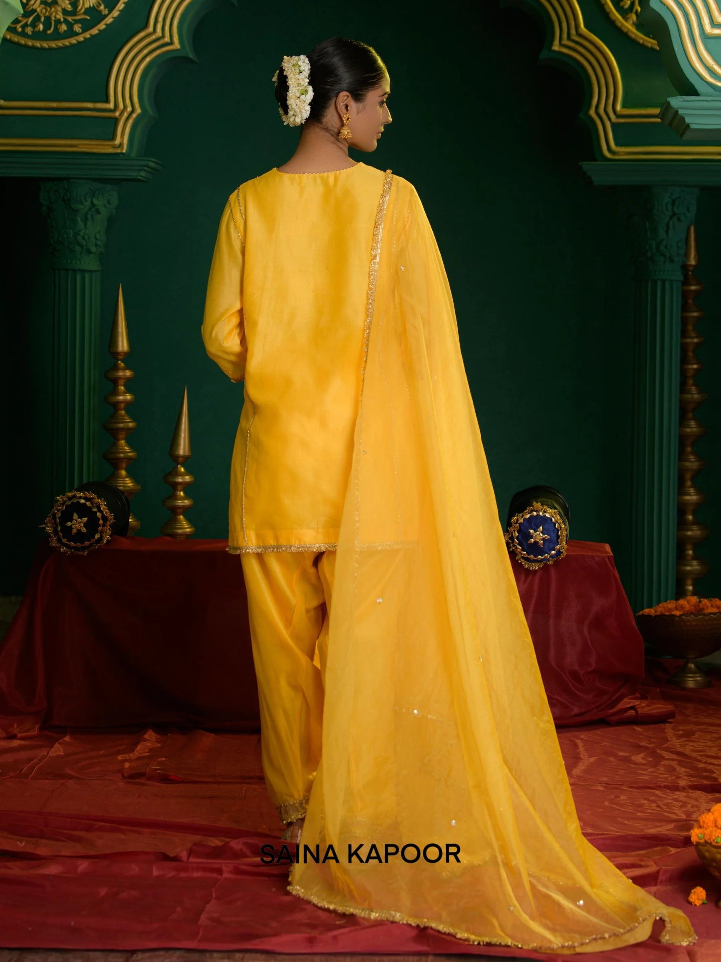 Back view of yellow Chanderi short kurta set for women with scattered sequin organza dupatta & gota patti embroidered ankle cuff dhoti salwar — Saina Kapoor