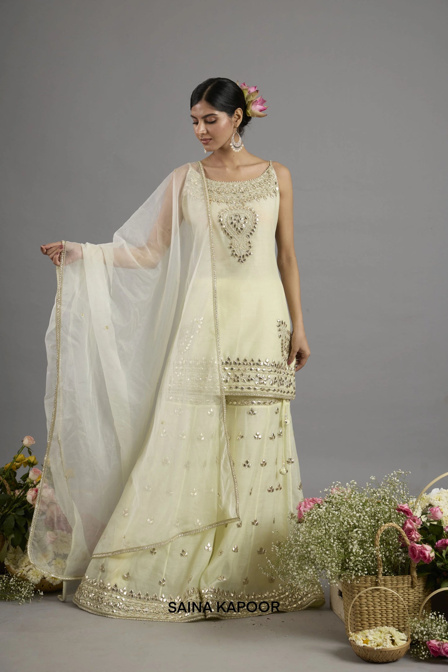 Afnan pale yellow Chanderi sleeveless kurta with gota patti round neckline paired with matching flared gharara and organza dupatta - Saina Kapoor