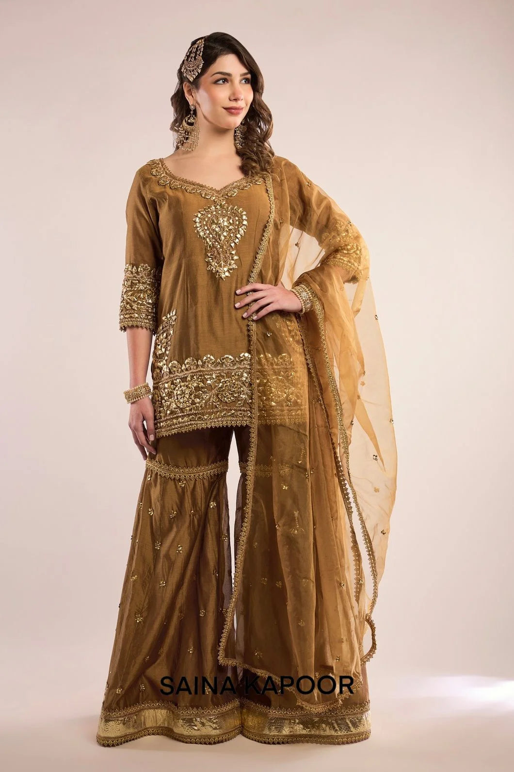 Gold Chanderi short kurta with gota patti embroidered curved V-neckline & matching gharara & champagne organza dupatta — Saina Kapoor