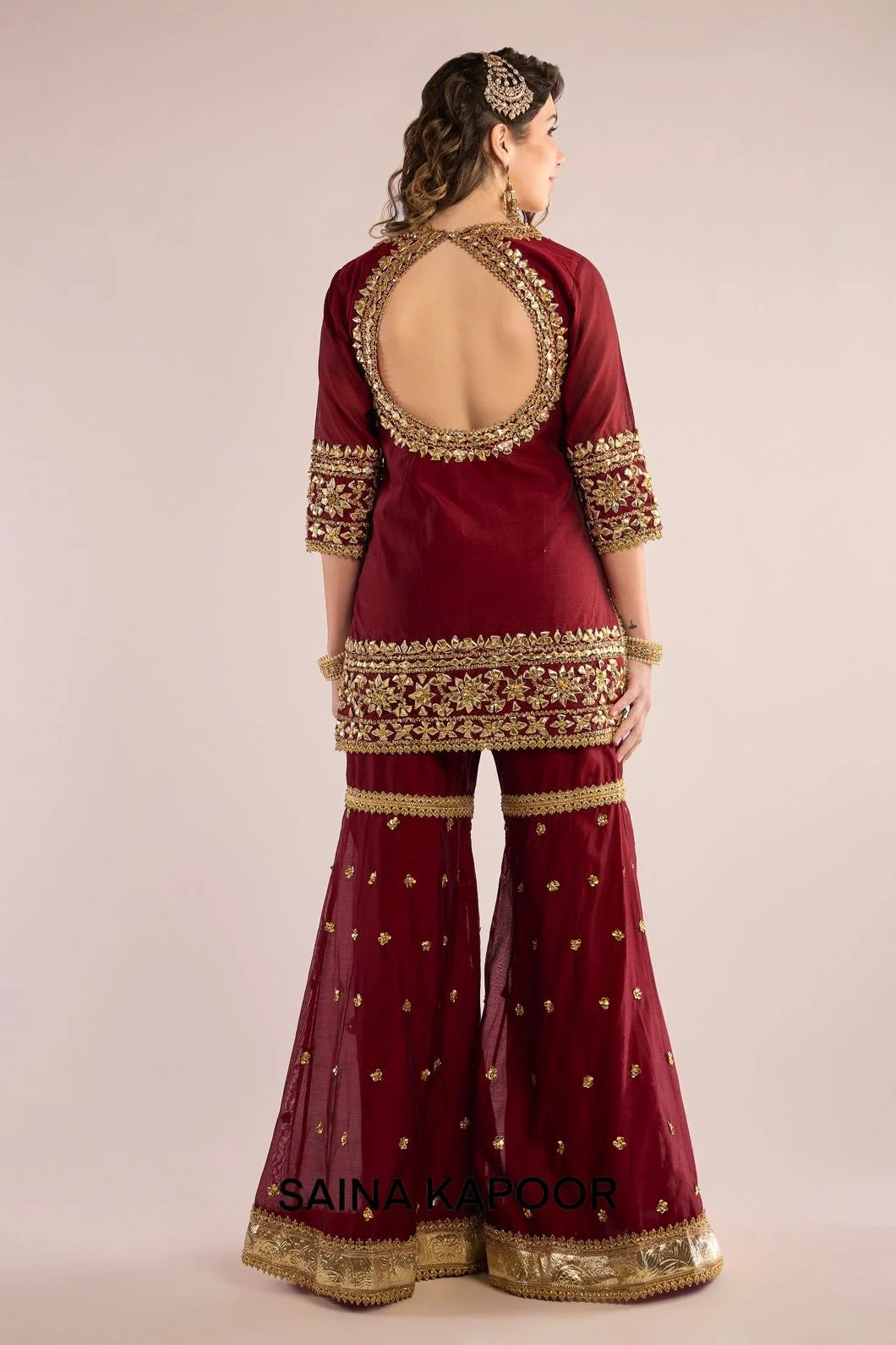 Back view of maroon Chanderi kurta gharara set for women with draped maroon organza dupatta — Saina Kapoor