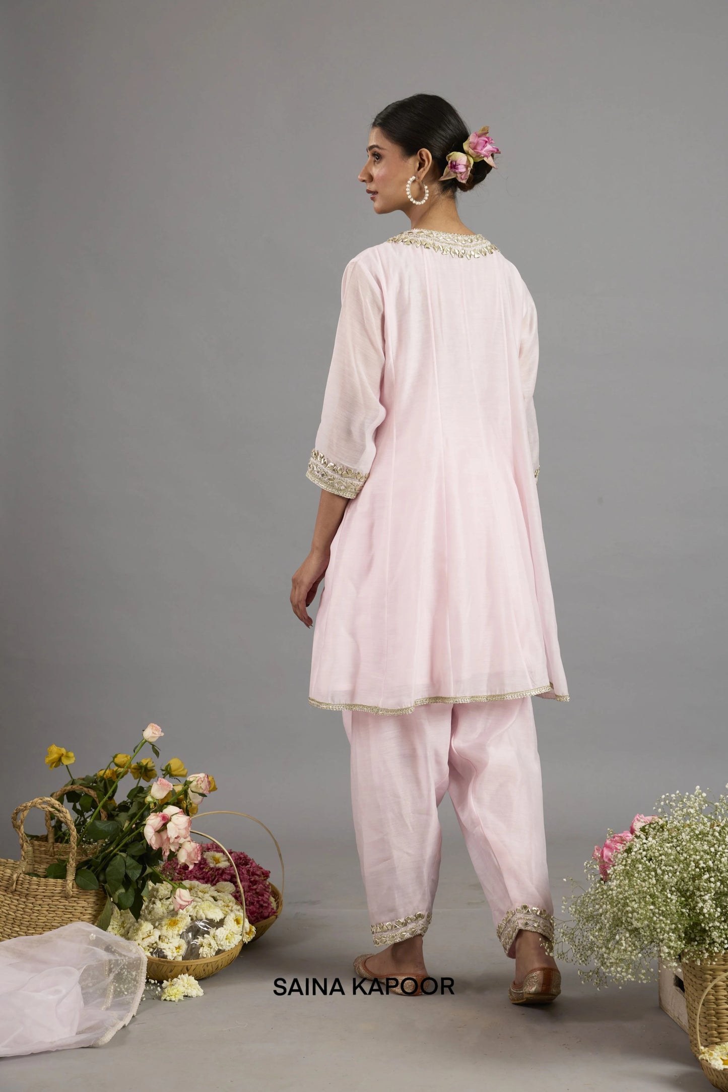 Afra baby pink Chanderi Anarkali back view with round neckline bordered in gota patti embroidery, three-quarter sleeves with embroidered cuffs, and matching salwar - Saina Kapoor
