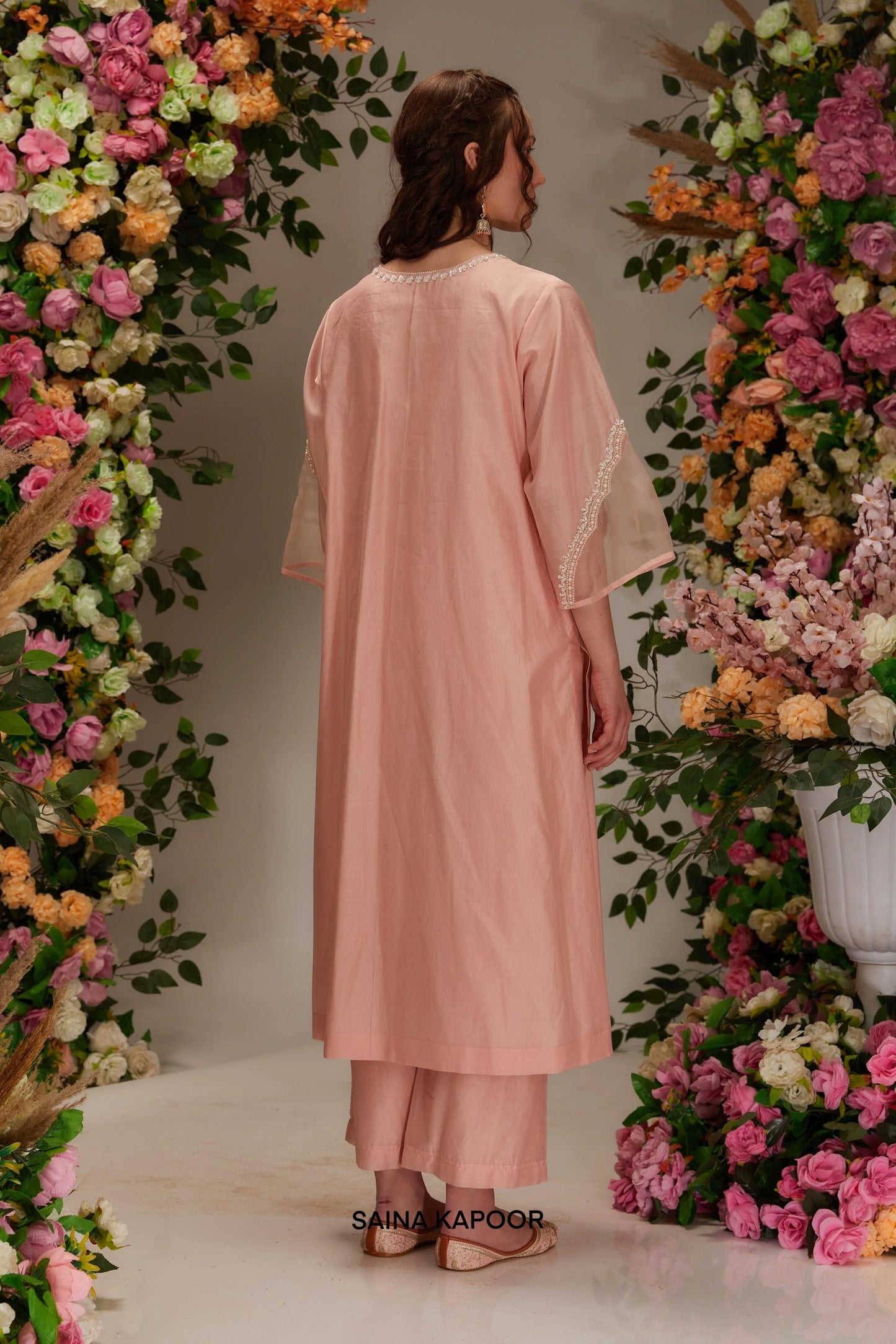 Back view of peach Chanderi long kurta set for women showing three-quarter angel sleeves & matching wide-leg palazzo pants — Saina Kapoor