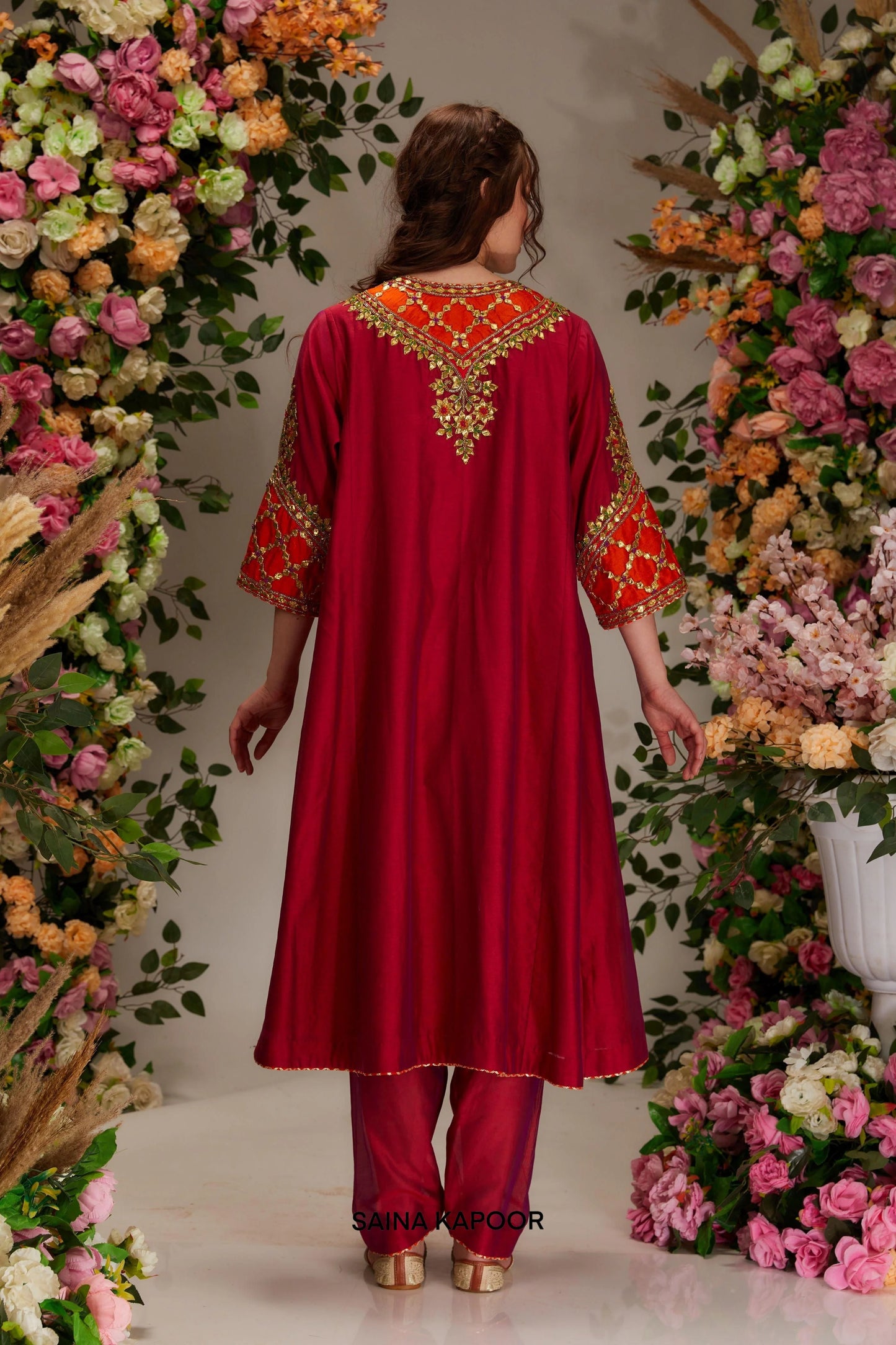 Back view of maroon Chanderi kalidar kurta set with flared silhouette & orange organza dupatta — Saina Kapoor