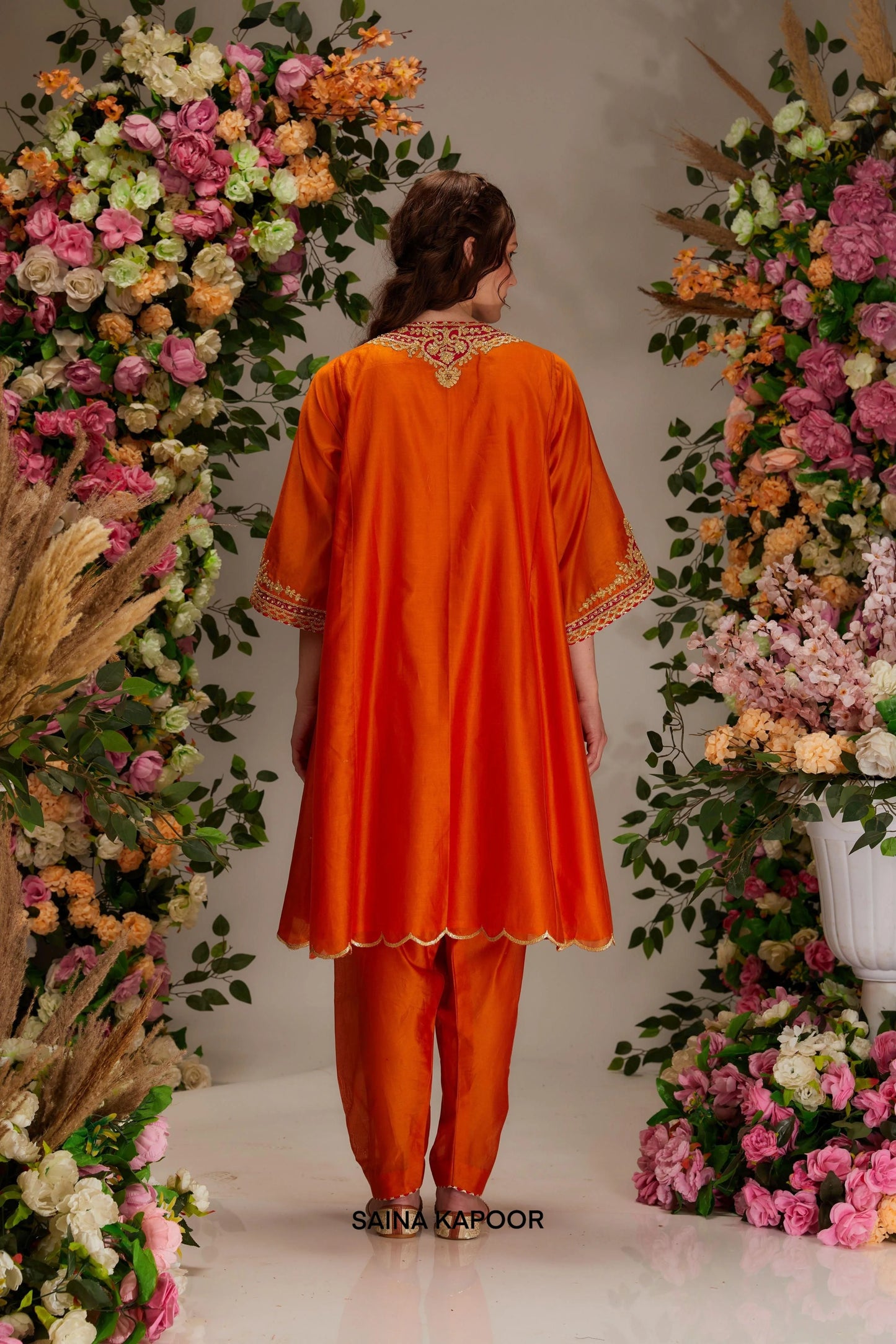Back view of orange Chanderi long kalidar kurta set with full sleeves & red organza dupatta — Saina Kapoor